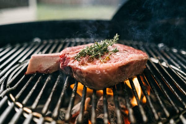 Cowboy Steak Being Grilled over Flames